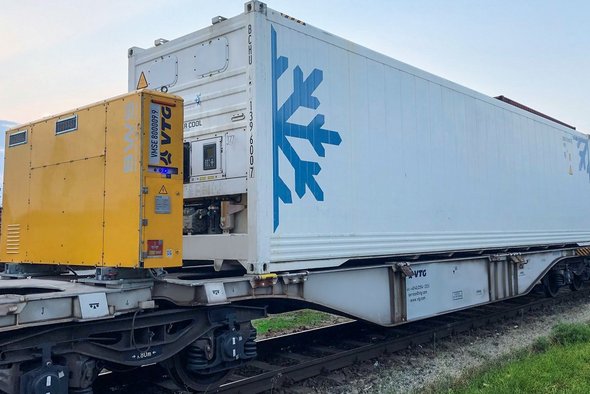 Gelbe Powerbox auf Intermodalwagen mit weißem Container