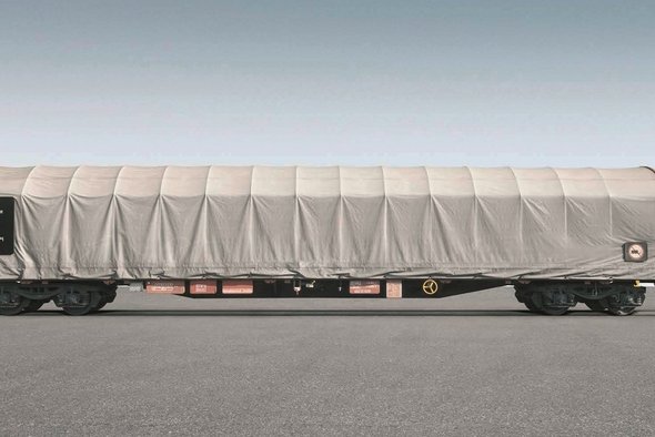 Flat car with white tarpaulin on gray background.