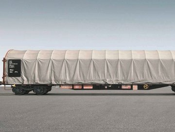 Flat car with white tarpaulin on gray background.