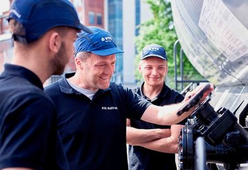 Three VTG employees inspect a valve on a wagon.