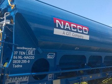 Blue hopper car with red logo against blue sky.