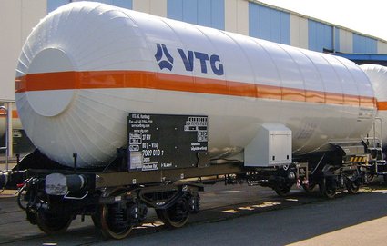 White liquid gas tank car with orange stripe and blue logo.