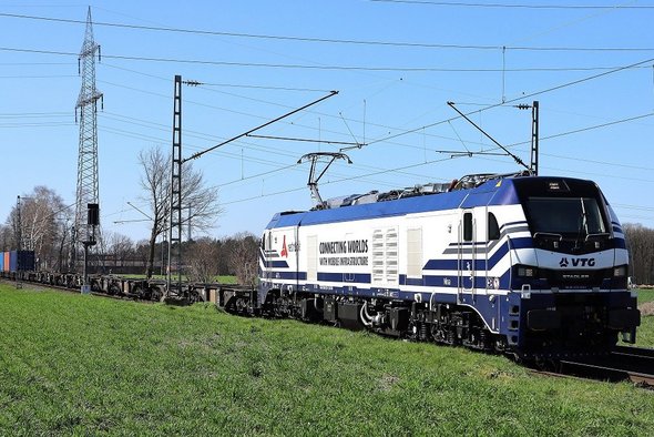 Whole VTG train runs on a track in front of green field.