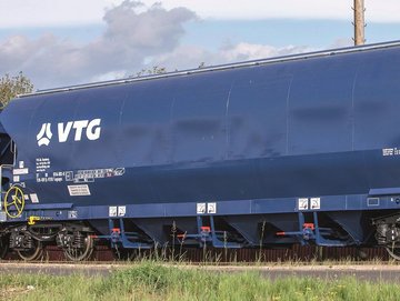 Blue hopper car with white VTG logo against green background.