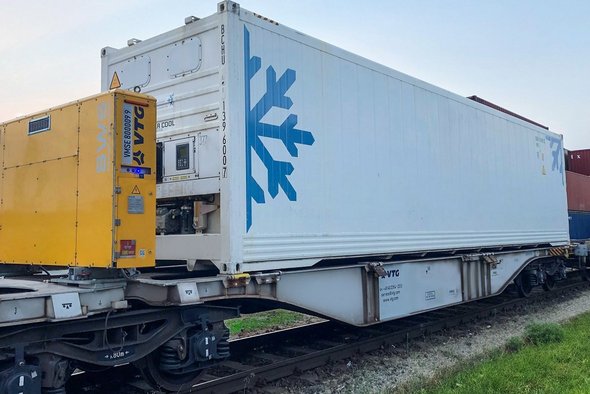 Gelbe Powerbox auf Intermodalwagen mit weißem Container