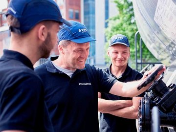 Three VTG employees inspect a valve on a wagon.