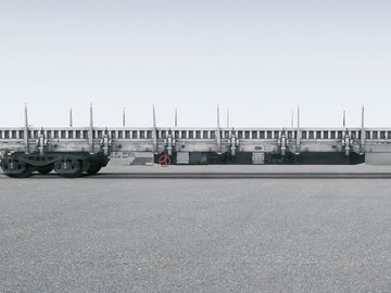 Gray metallic flat car with side elements on gray background.