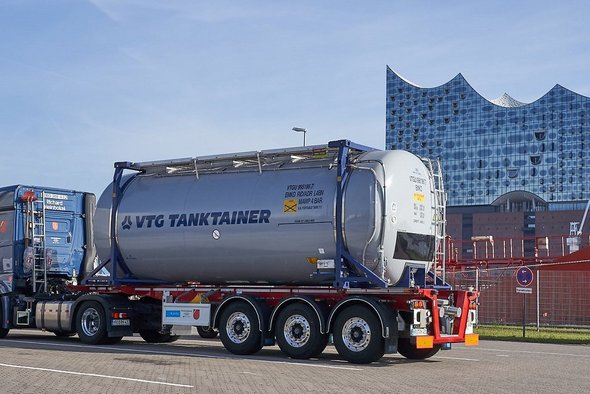 Gray VTG tank container on a blue truck in front of the Elbphilarmonie concert hall in Hamburg.