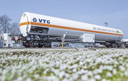 White liquid gas tank car with orange stripe and blue logo.