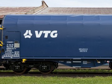 Blue flat car with white VTG logo on one rail.