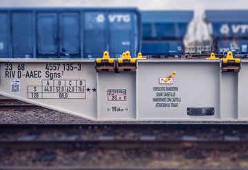 Gray flat wagon in front of three blue high wagons