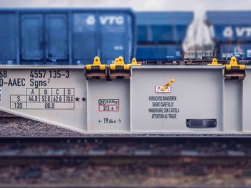 Gray flat wagon in front of three blue high wagons