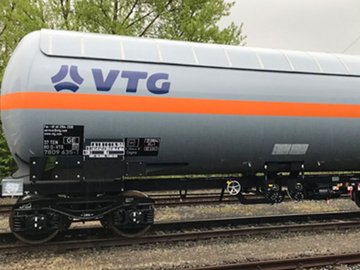 White liquid gas tank car with orange stripe and blue logo.