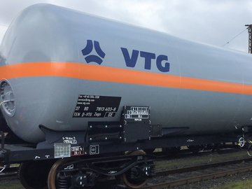 Gray liquid gas tank car with orange stripe and blue VTG logo.