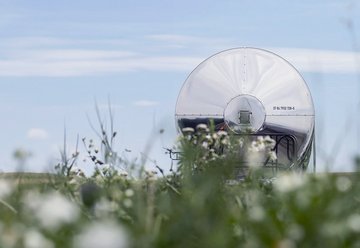 Silberner Kesselwagen mit Wiese im Vordergrund