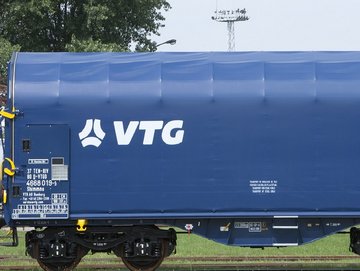 Blue flat car with white VTG logo on a rail.
