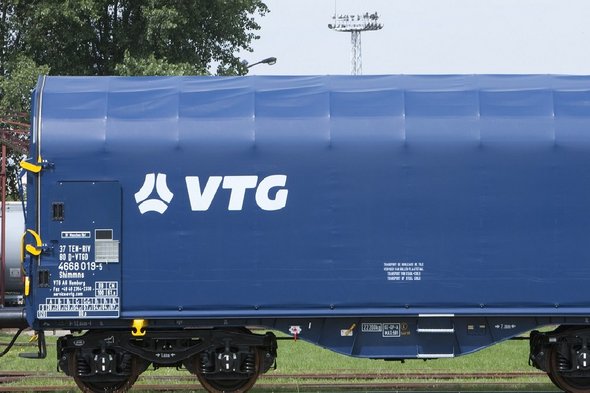 Blue flat car with white VTG logo on a rail.